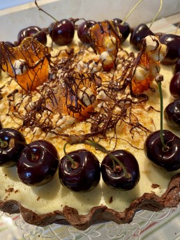 A large chocolate tart with hazelnut praline and cherries