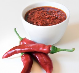 A bowl of vibrant red pepper sauce