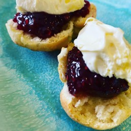 a scone topped with raspberry jam and clotted cream