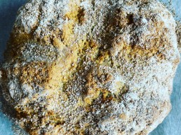 A handmade loaf of soda bread dusted with flour