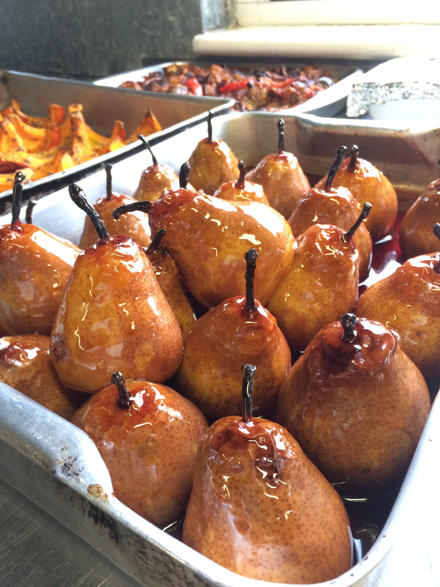 Pears in a roasting tin covered in red wine caramel sauce