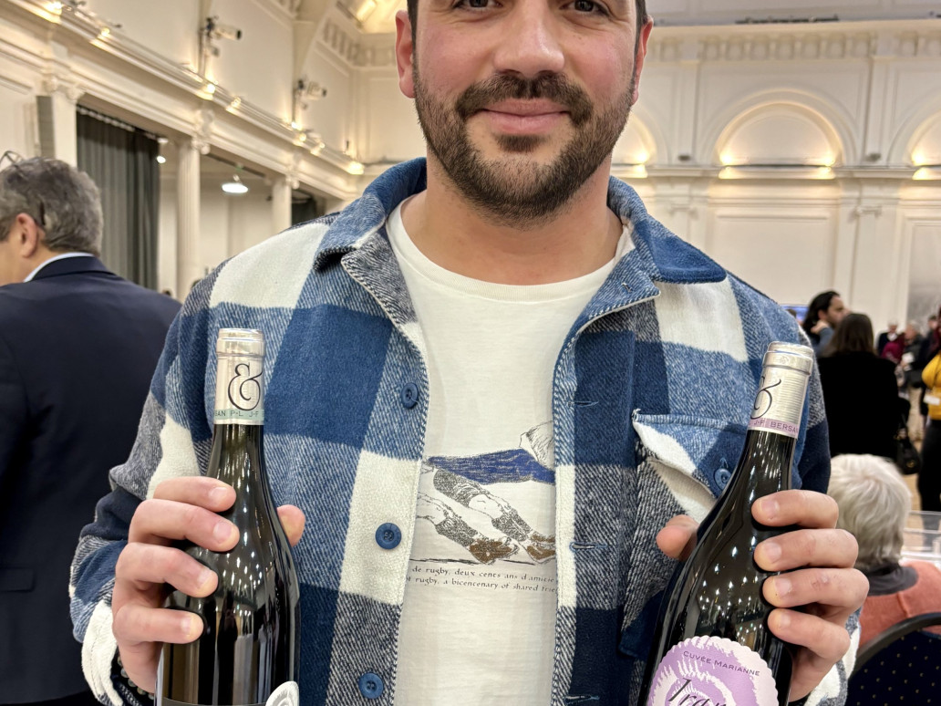 A man holding two bottles of Domaine Bersan wine