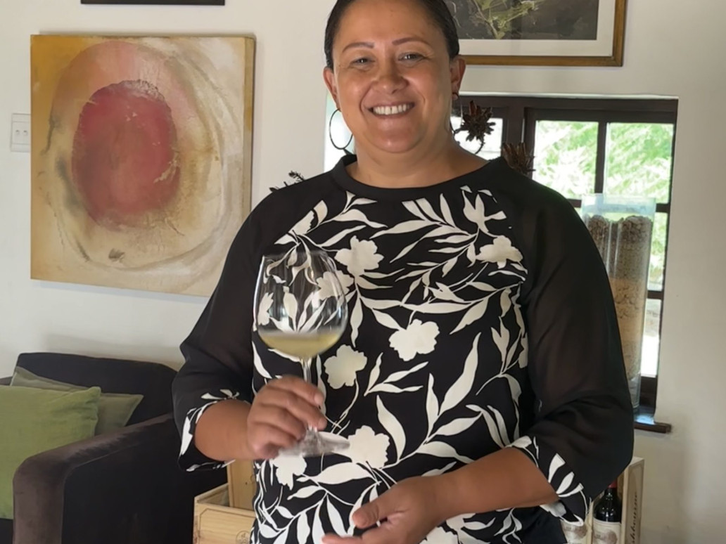 A smiling woman holding a wine glass