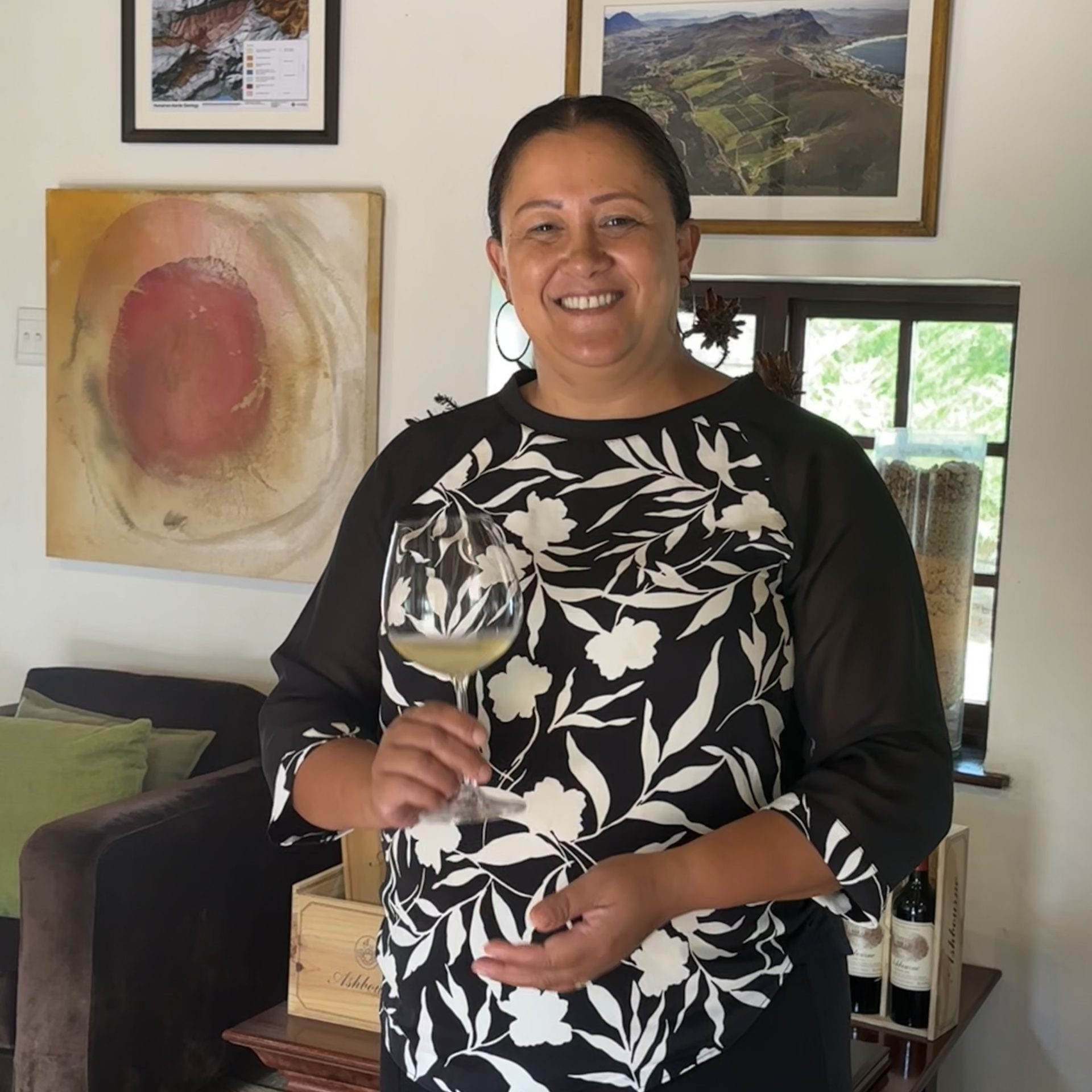 A smiling woman holding a wine glass