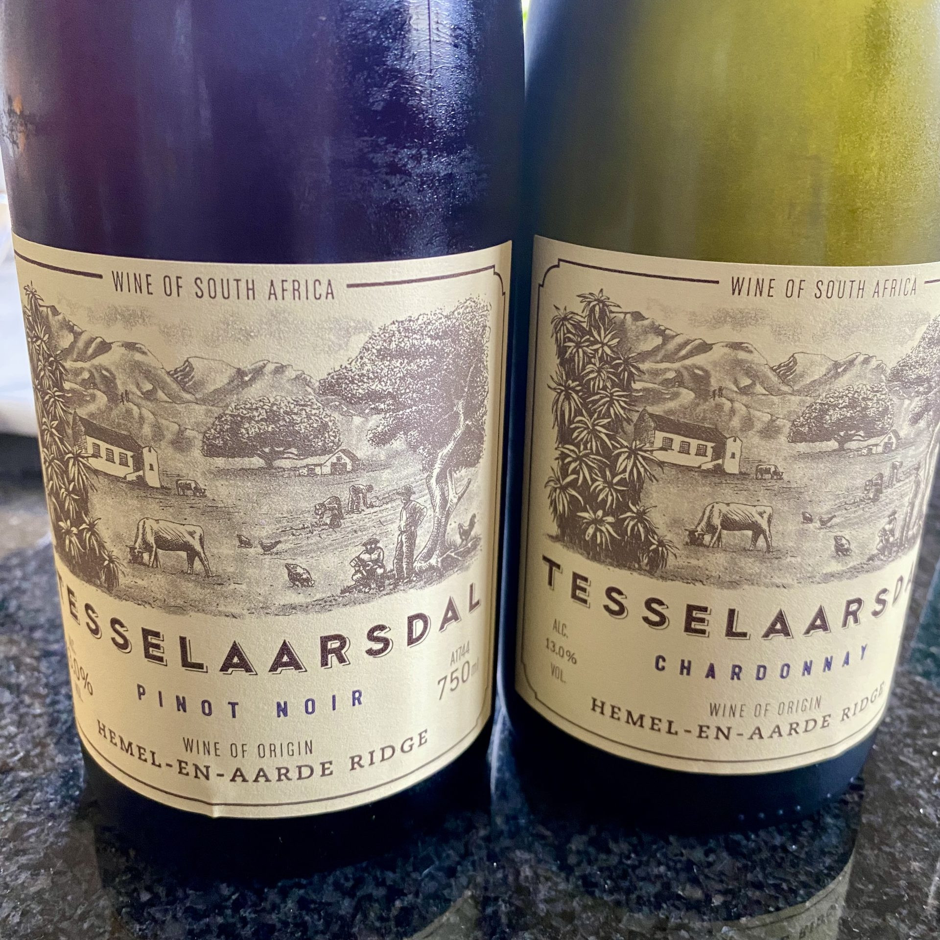 Two wine bottles, one white, one red, glistening with condensation