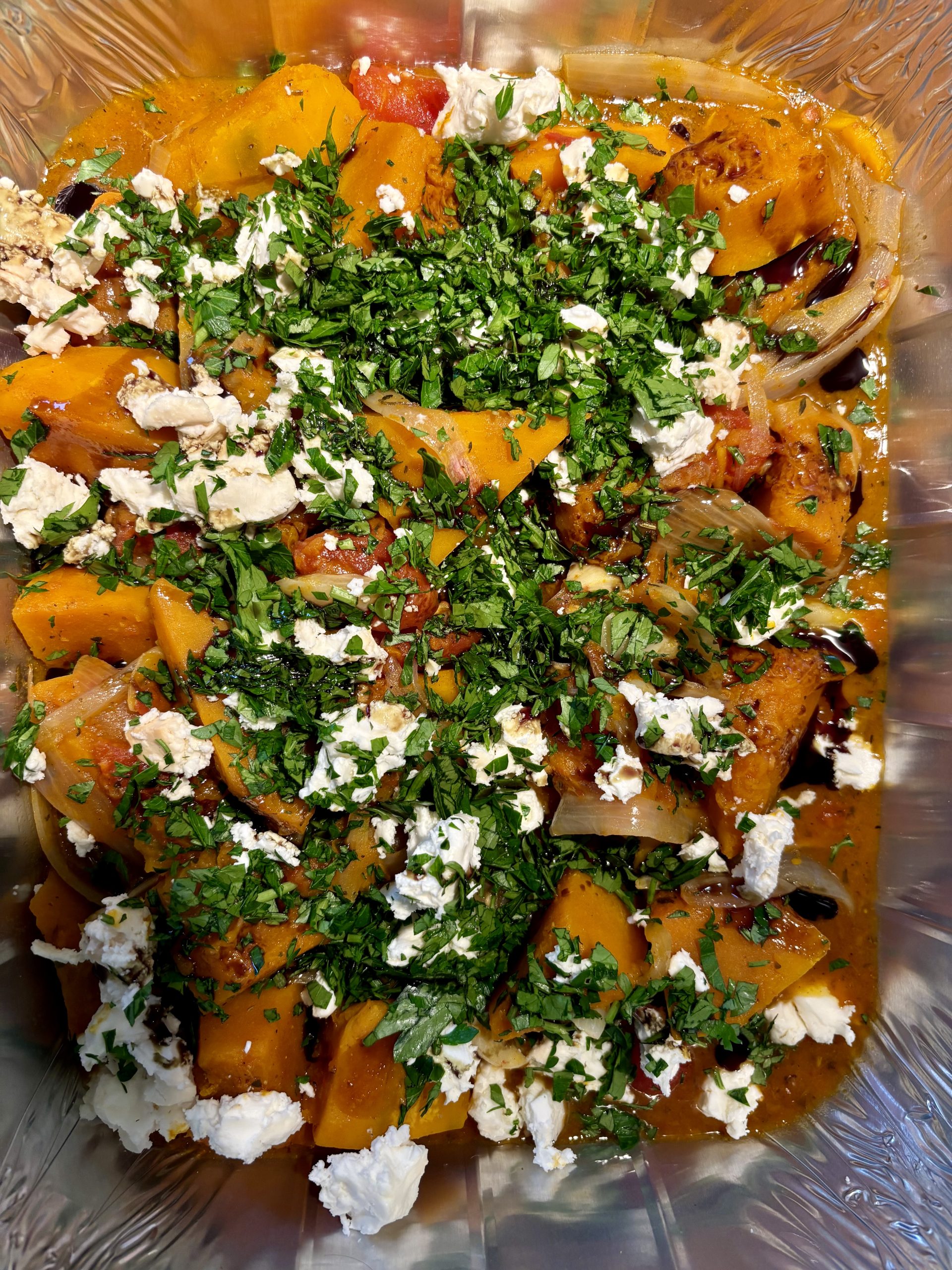 Brightly coloured braised pumpkin with tomatoes, feta, chilli and pumpkin seed oil