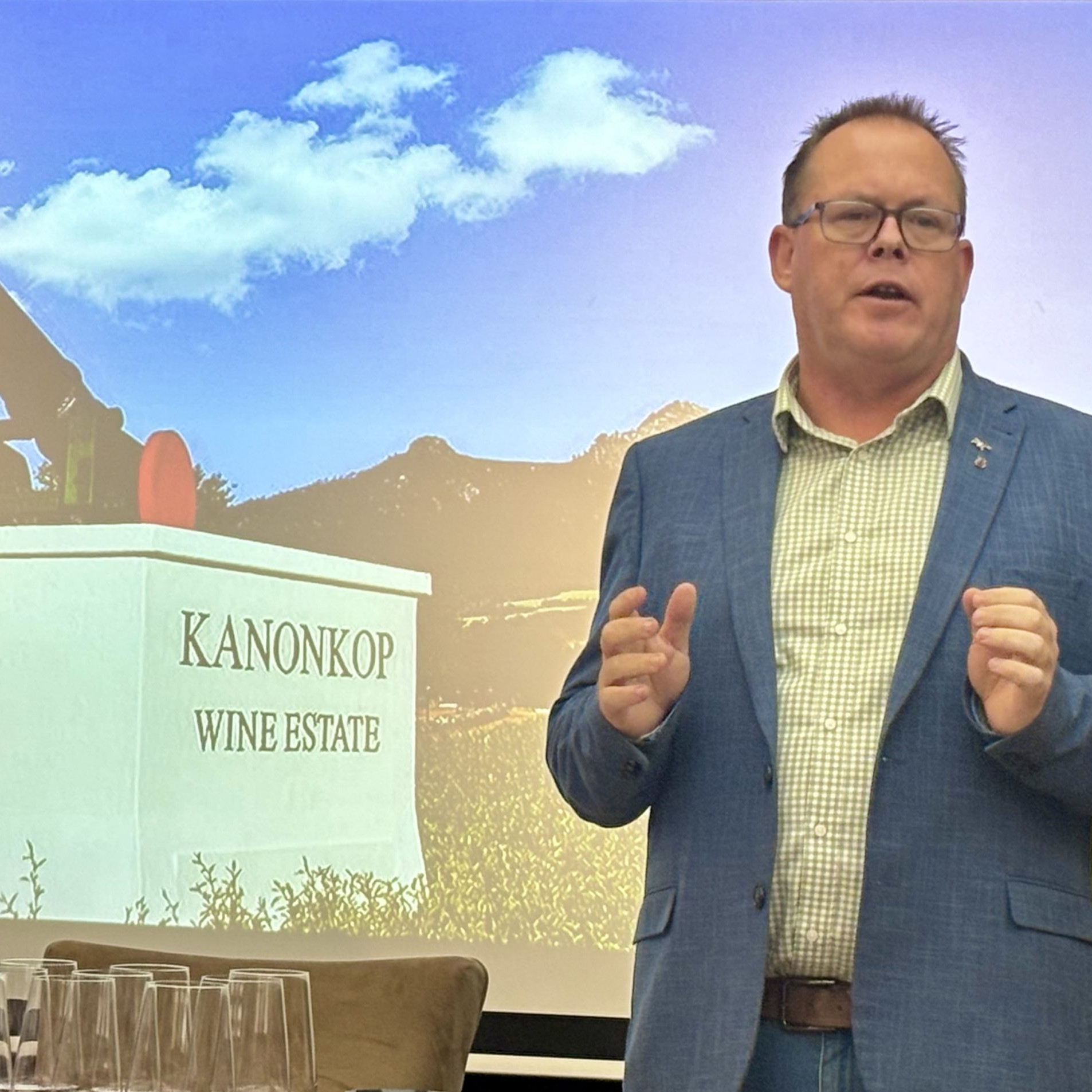 A man stands in front of a photograph of a canon on a concrete block at the entrance to the Kanonkop wine estate