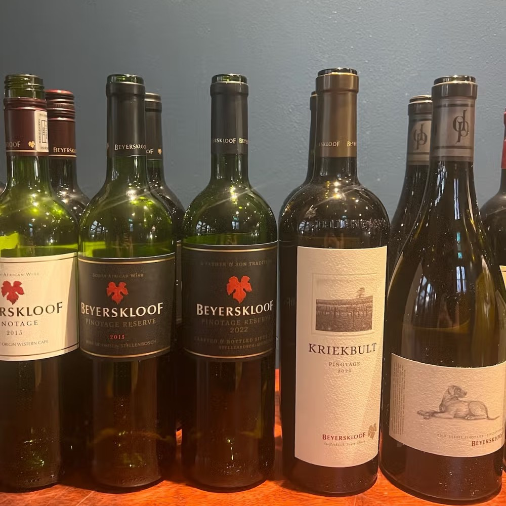 A row of red wine bottles with the Beyerskloof label including one with a large dog on it, called Diesel