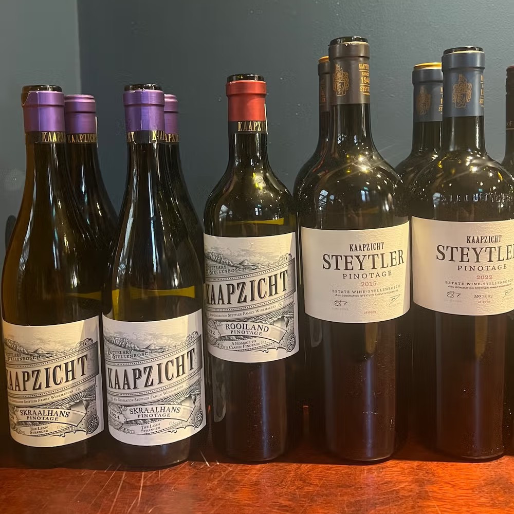 A row of red wine bottles with bold labels that read Kaapzicht and Steytler