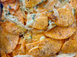 A dish of bright orange sweet potato baked with sage, shallot and cream