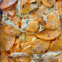A dish of bright orange sweet potato baked with sage, shallot and cream